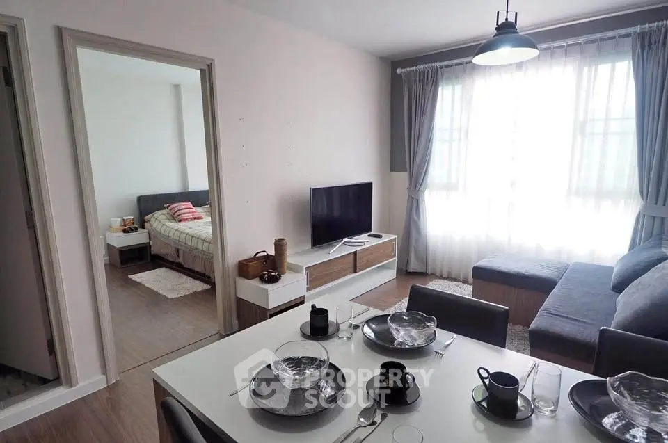 Modern living room with dining area and bedroom view, featuring stylish decor and natural light.