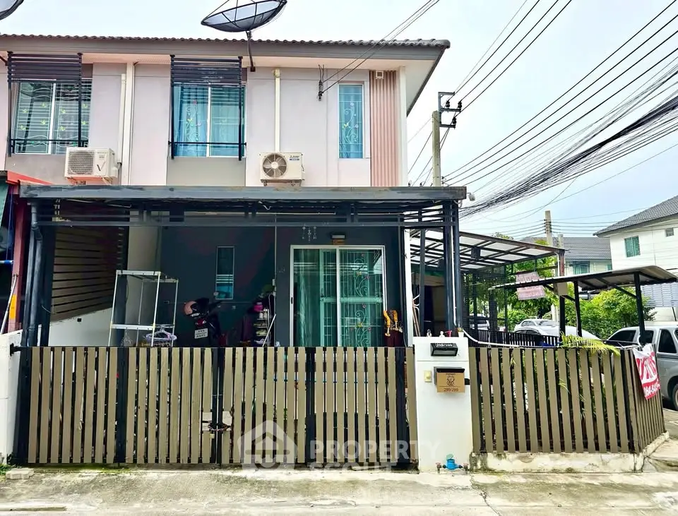Charming two-story townhouse with modern facade and gated front yard in a serene neighborhood.