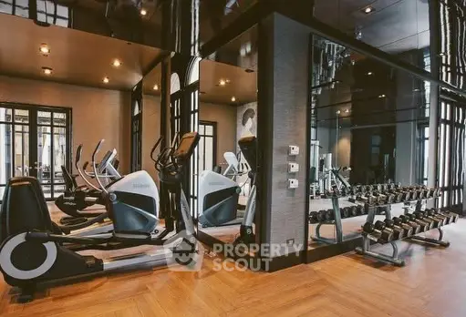 Luxurious gym with modern equipment and mirrored walls in upscale residential building.