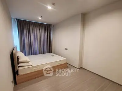 Minimalist bedroom with bed and curtains, ideal for cozy living.