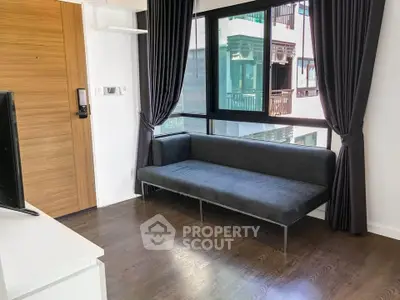 Modern living room with sleek sofa and large windows offering natural light