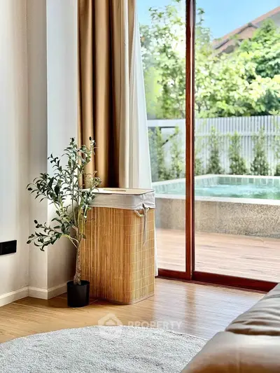 Elegant living room with pool view, featuring stylish decor and natural light.