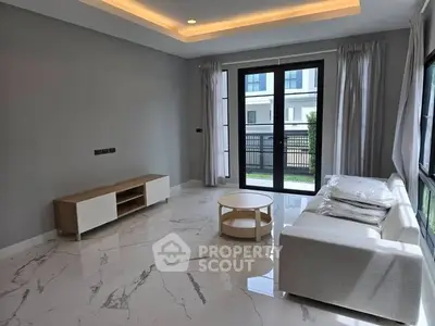 Modern living room with marble flooring and large windows in a stylish home.
