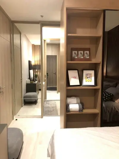 Modern bedroom with stylish decor and built-in shelving, perfect for urban living.
