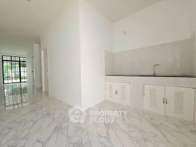 Spacious modern kitchen with sleek marble flooring and minimalist design