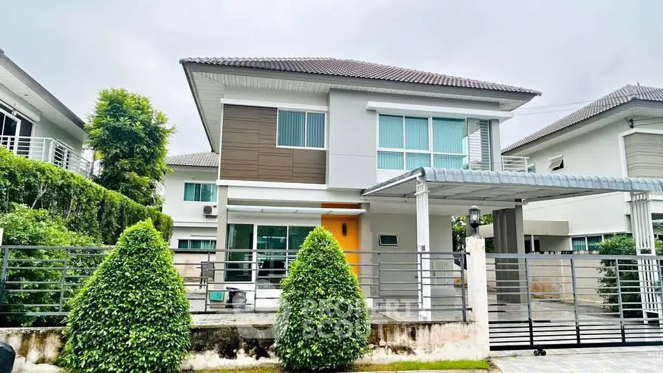 Modern two-story house with landscaped garden and gated driveway