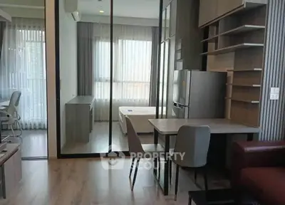 Modern apartment interior with open layout, featuring a cozy living area and a view into the bedroom.
