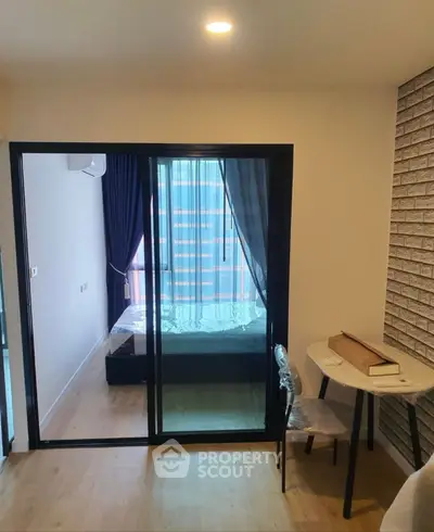 Modern bedroom with glass sliding doors and cozy study area