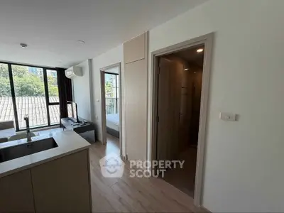 Modern apartment interior with open layout and large windows offering natural light and scenic views.