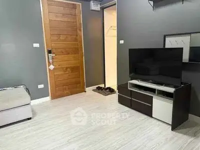 Modern living room with sleek TV stand and wooden door, perfect for cozy evenings.