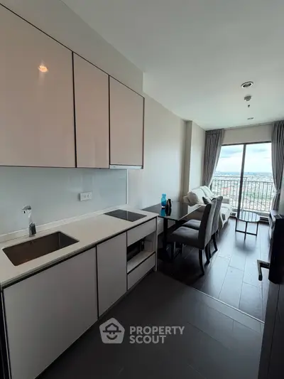 Modern open-layout kitchen with sleek cabinets and dining area, offering a stunning city view from the balcony.