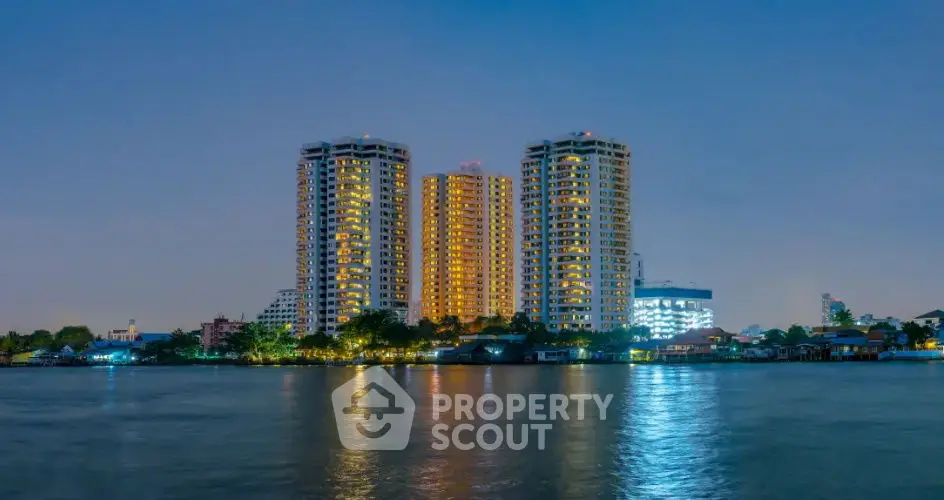 Stunning waterfront high-rise buildings with illuminated windows at dusk.