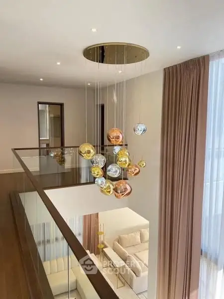 Elegant modern living room with unique chandelier and glass railing