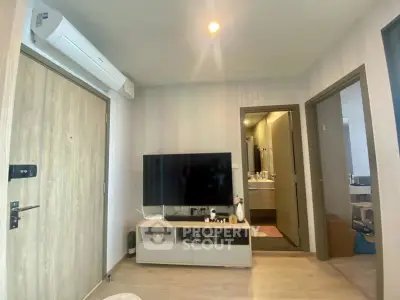 Modern living room with sleek TV setup and air conditioning, showcasing contemporary interior design.