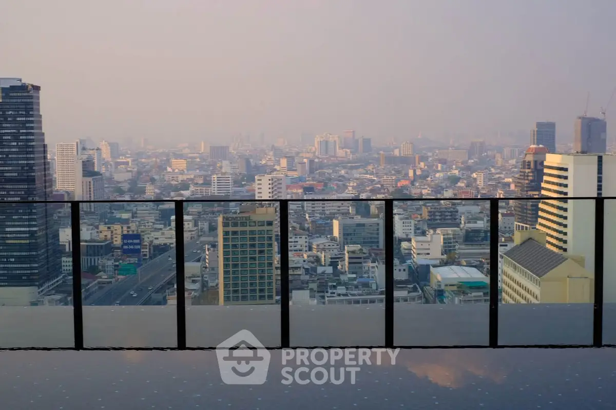 Stunning cityscape view from a modern rooftop pool with glass railing.