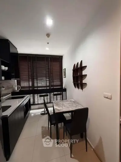 Modern kitchen with sleek black cabinets and dining area
