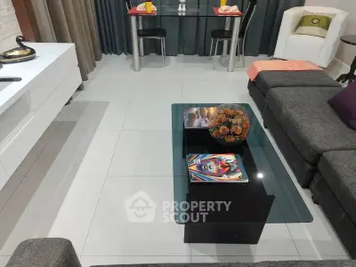 Modern living room with stylish furniture and glass coffee table, perfect for cozy gatherings.