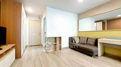 Modern living room with stylish decor and ample natural light, featuring a cozy sofa and sleek wooden flooring.