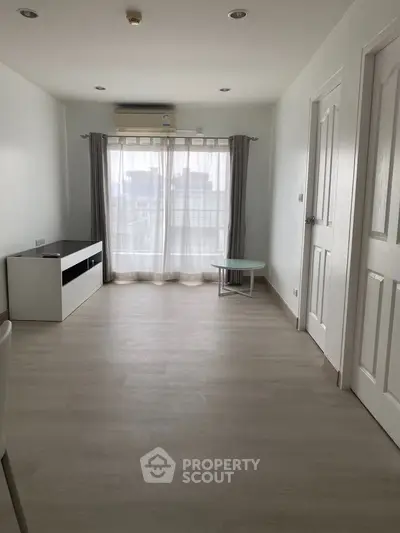 Spacious minimalist living room with large window and modern flooring