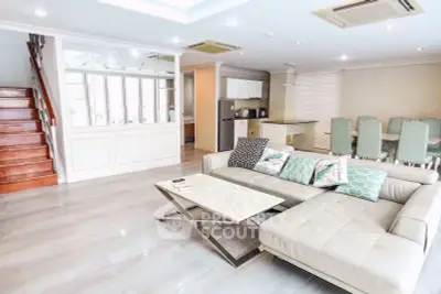 Spacious modern living room with elegant staircase and open dining area