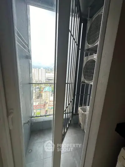 High-rise apartment balcony with city view and air conditioning units.