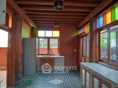 Charming rustic kitchen with colorful stained glass windows and wooden beams.