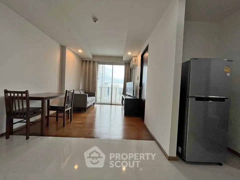 Modern living room with dining area and balcony view in a stylish apartment.