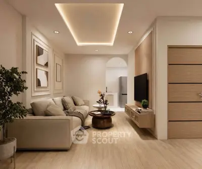 Modern living room with elegant ceiling lights and cozy sofa, open layout leading to kitchen area.