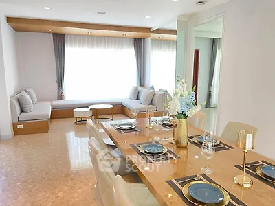 Elegant dining area with luxurious table setting and cozy seating by large window.