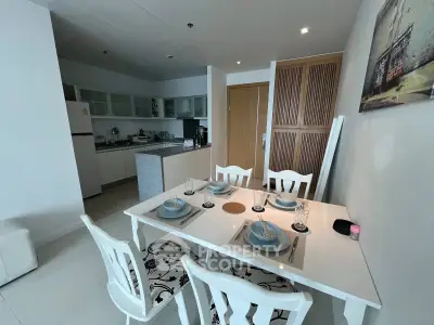 Modern kitchen and dining area with elegant white furniture and stylish decor