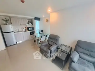Modern open-layout living room with kitchen, featuring cozy seating and dining area.