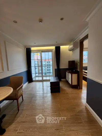 Spacious living room with elegant decor and balcony access in modern apartment.