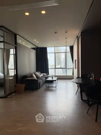 Spacious modern living room with large windows offering stunning city views, elegant furnishings, and stylish decor.