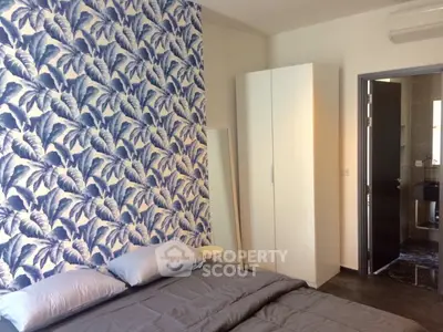 Stylish bedroom with tropical wallpaper and modern furnishings