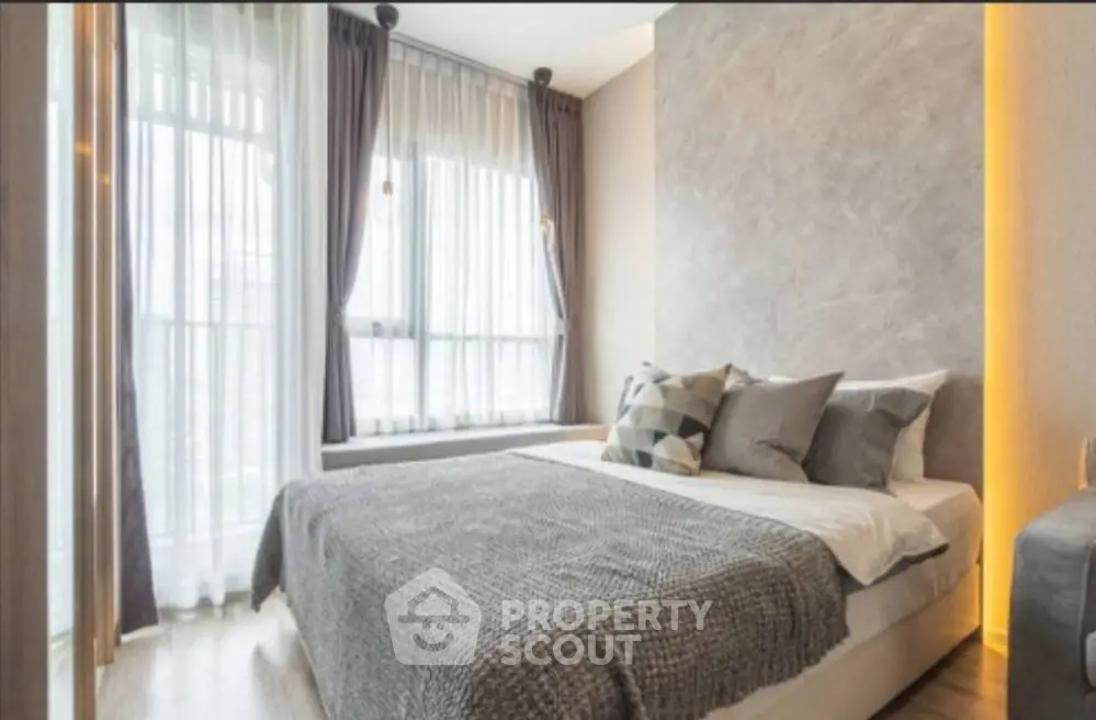 Modern bedroom with large windows and stylish decor in a luxury apartment.