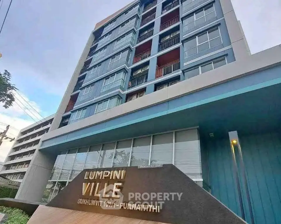 Modern condominium building exterior with Lumpini Ville signage in urban setting.