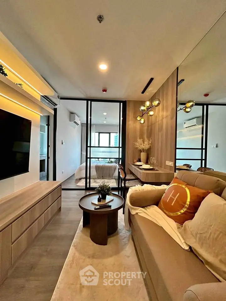 Modern living room with cozy sofa, stylish decor, and open view to bedroom in luxury apartment.