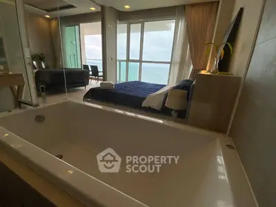Luxurious bedroom with ocean view and modern bathtub in open layout design.