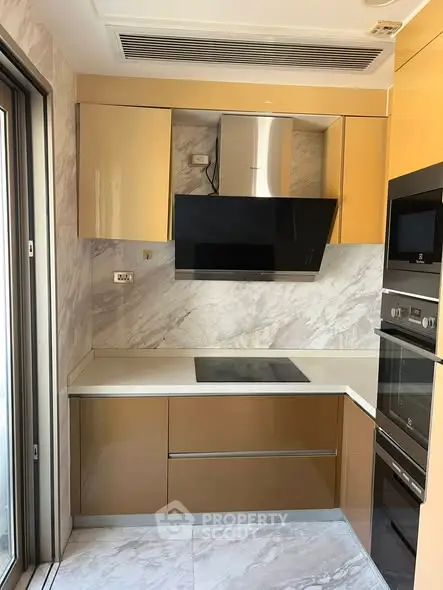 Modern kitchen with sleek cabinetry and built-in appliances, featuring a minimalist design and marble accents.
