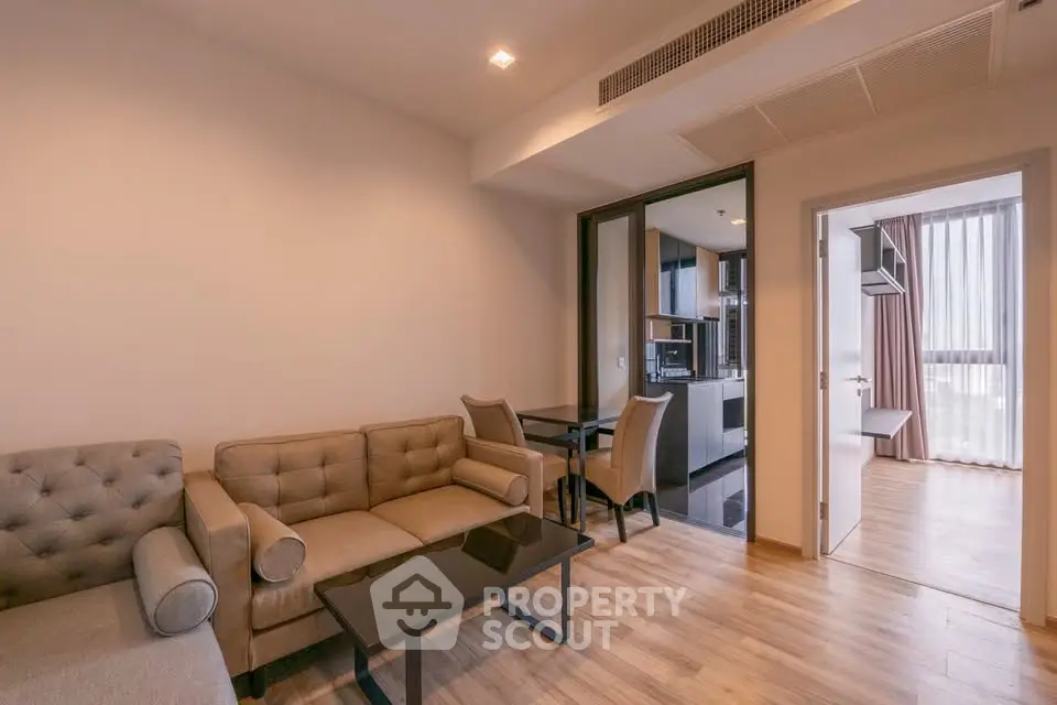 Modern living room with cozy seating and open kitchen in stylish apartment