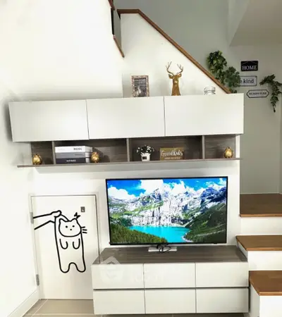 Modern living room with stylish decor and wall-mounted TV under staircase