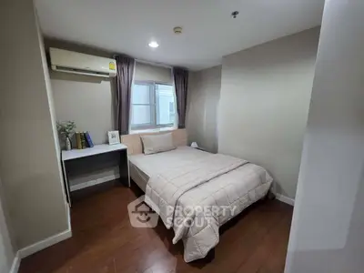 Cozy bedroom with modern decor and wooden flooring, featuring a comfortable bed and study desk.