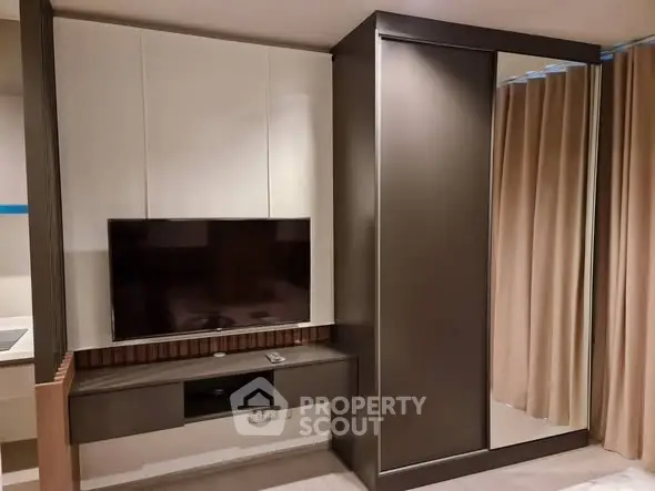 Modern living room with sleek TV unit and floor-to-ceiling curtains