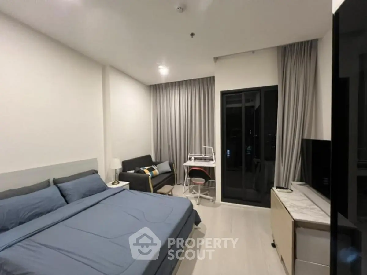 Modern bedroom with cozy decor and balcony access in urban apartment