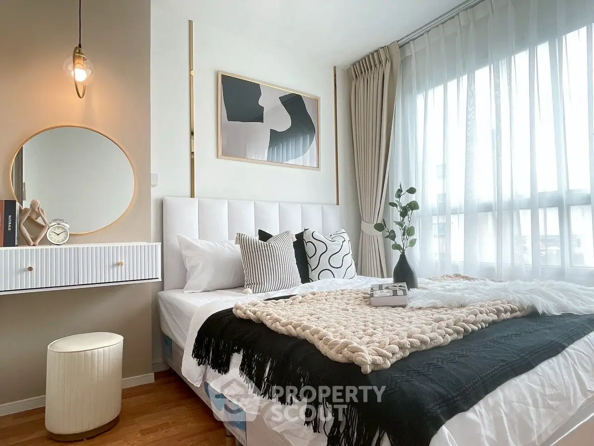 Stylish bedroom with modern decor, large window, and cozy bedding