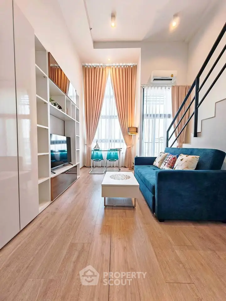 Modern living room with high ceilings, stylish decor, and natural light.