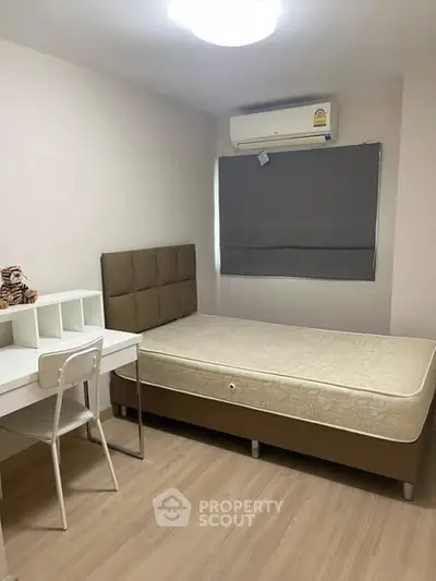 Cozy bedroom with modern furnishings and air conditioning, perfect for comfortable living.