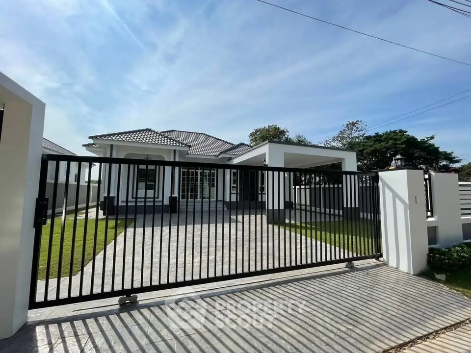 Modern single-story house with gated entrance and spacious driveway