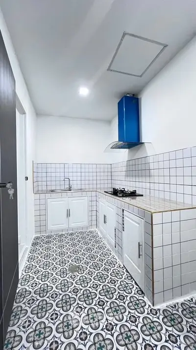 Modern kitchen with stylish tile flooring and sleek gas stove in a compact layout.