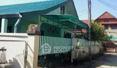 Charming single-story home with green roof and fenced yard in a quiet neighborhood.